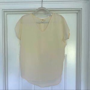 Beige blouse with cap sleeve.